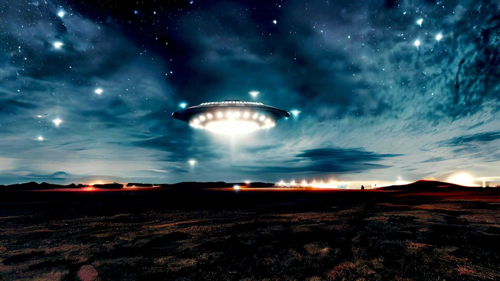 Ein Ufo über einer Wüste, im Hintergrund Bebauung.